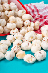Organic Crispy Lotus pops Seeds or Phool Makhana served in a wooden bowl on background.