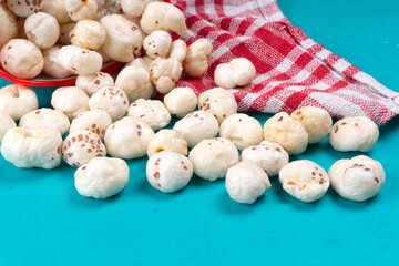 Organic Crispy Lotus pops Seeds or Phool Makhana served in a wooden bowl on background.