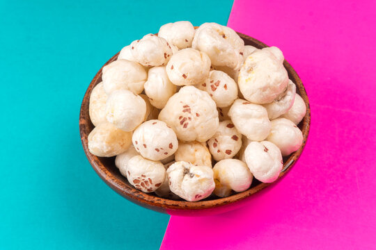 Organic Crispy Lotus pops Seeds or Phool Makhana served in a wooden bowl on background.