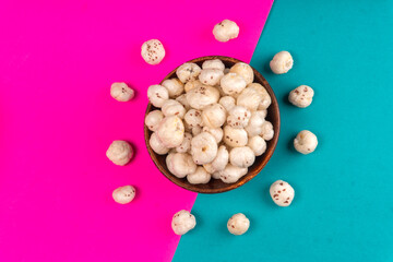 Organic Crispy Lotus pops Seeds or Phool Makhana served in a wooden bowl on background.