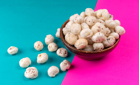 Organic Crispy Lotus pops Seeds or Phool Makhana served in a wooden bowl on background.