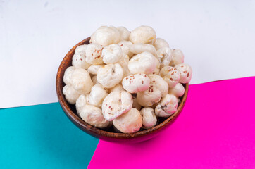 Organic Crispy Lotus pops Seeds or Phool Makhana served in a wooden bowl on background.