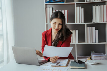 Asian businesswoman in formal suit in office happy and cheerful during using smartphone and working