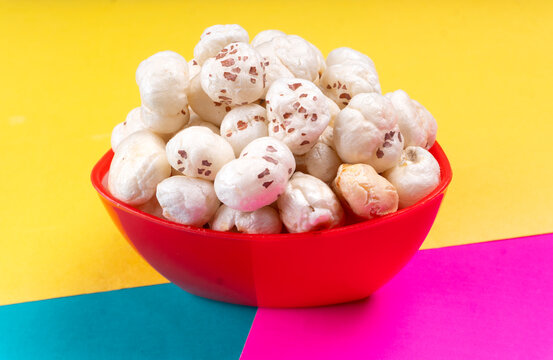 Organic Crispy Lotus pops Seeds or Phool Makhana served in a wooden bowl on background.