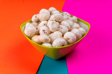 Organic Crispy Lotus pops Seeds or Phool Makhana served in a wooden bowl on background.