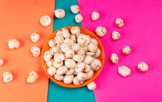 Organic Crispy Lotus pops Seeds or Phool Makhana served in a wooden bowl on background.