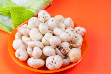 Organic Crispy Lotus pops Seeds or Phool Makhana served in a wooden bowl on background.