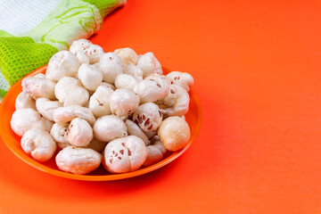 Organic Crispy Lotus pops Seeds or Phool Makhana served in a wooden bowl on background.