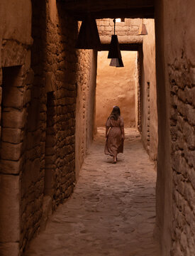 A little Girl runs in the alleys of Alula., a restored old town, 900 years old historical village in Medina, Saudi Arabia.	