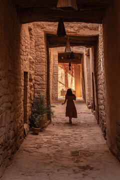 A little Girl runs in the alleys of Alula., a restored old town, 900 years old historical village in Medina, Saudi Arabia.	