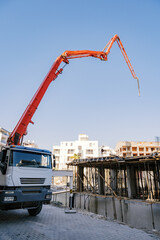 Concrete mixer truck with concrete supply pump at construction site