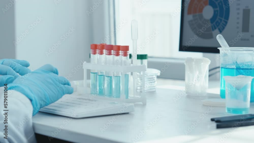 Poster a female researcher sits at a workplace in a laboratory, behind a personal computer monitor. against
