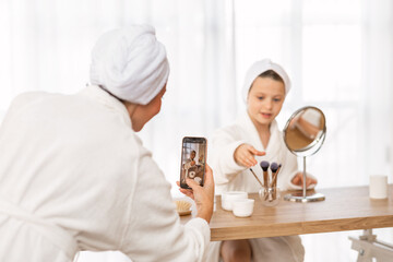 Sharenting Concept. Mother Taking Photo Of Her Daughter Doing Makeup At Home