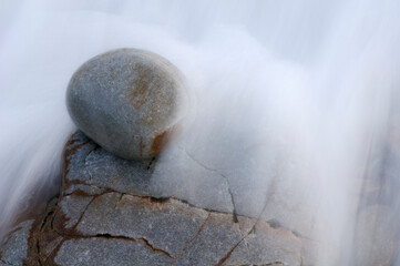 Wave and stone on the beach