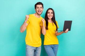 Photo of funny excited married couple wear yellow t-shirts communicating twitter telegram isolated...