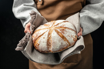 Homemade sourdough bread in hand. Healthy food concept. place for text, top view - obrazy, fototapety, plakaty