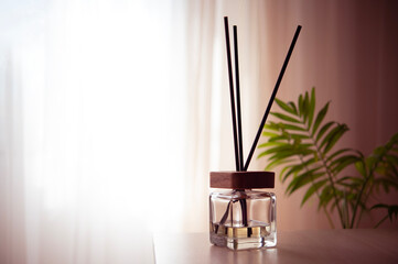 Flavored diffuser for interior decor. A stylish glass bottle with perfumed liquid, sticks and a...