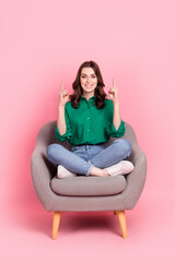Obraz na płótnie Canvas Full length photo of cute charming lady dressed green blouse sitting sofa showing two empty space isolated pink color background