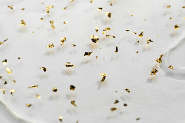 Gel background with gold particles, selective focus. Beauty skin care product close-up