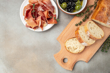 Antipasto of ham, crostini with prosciutto, olives and glass of red wine