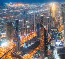 Naklejka na ściany i meble Aerial View Of Urban Background Of Illuminated Cityscape With Skyscrapers In Dubai. Street Night Traffic In Dudai Skyline. Moving through modern city street with illuminated. UAE, United Arab Emirates