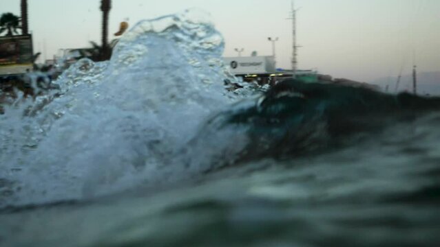 Small barrel wave breaking on a riff in Eilat at sunset.