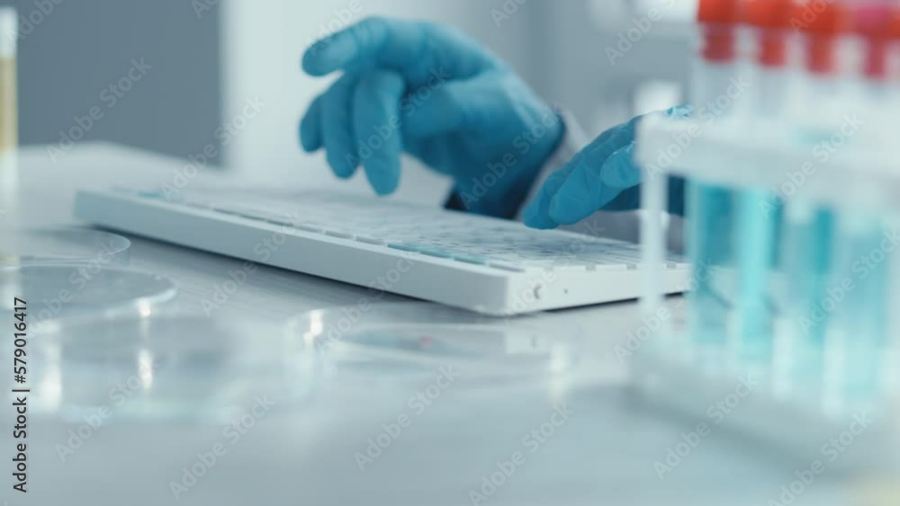 Poster a female researcher sits at a workplace in a laboratory, behind a personal computer monitor. against