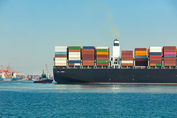 Large cargo container ship loaded with containers against the blue sky