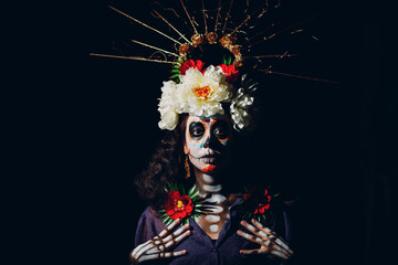 Woman with mexican skull halloween makeup on face. Day of the dead aka Dia de los Muertos and halloween concept.
