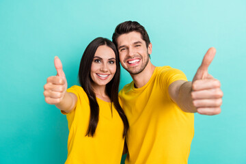 Photo of charming positive husband wife dressed yellow t-shirts cuddling showing you thumbs up...