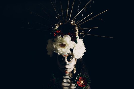 Woman with mexican skull halloween makeup on face. Day of the dead aka Dia de los Muertos and halloween concept.