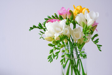 Bouquet of spring freesia flowers in a glass