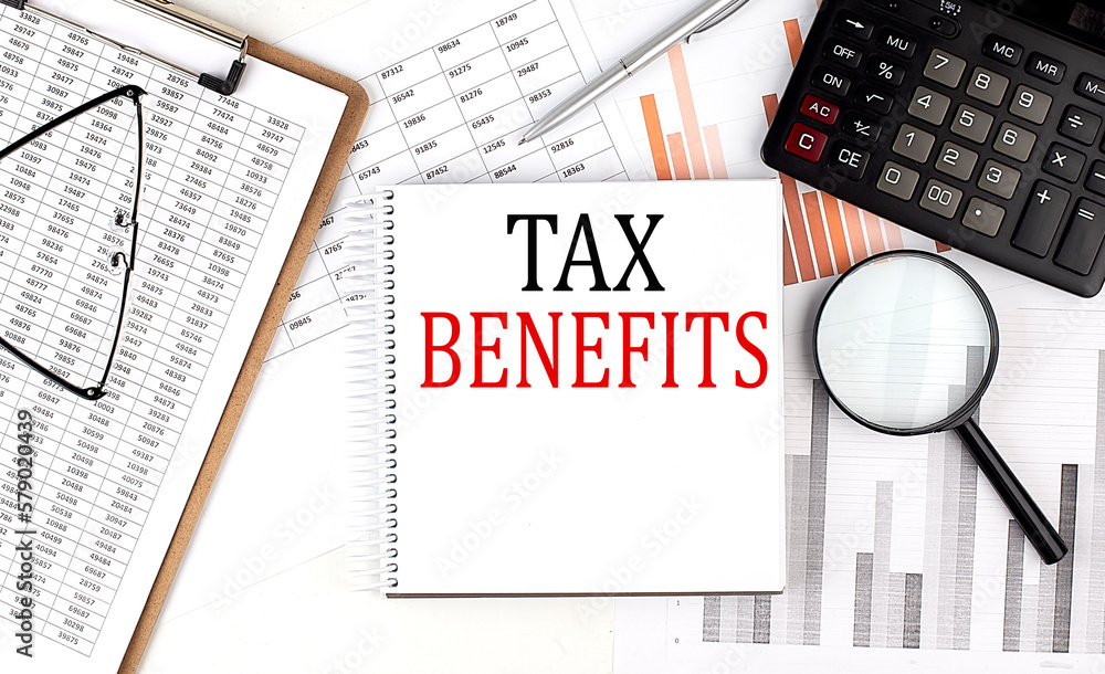 Poster tax benefits text on notebook with clipboard and calculator on a chart background