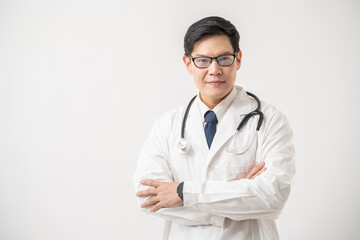 Portrait of confident Asian Doctor in glasses with stethoscope standing with arms crossed on white background