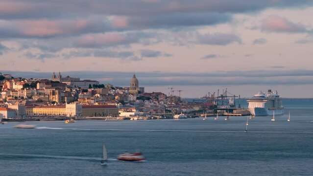 Timelapse of Lisbon historic district view from Almada over Tagus river with yachts and ferry boats on sunset. Lisbon, Portugal. Zoom in effect