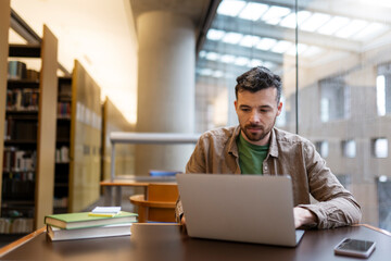 Pensive latin student studying, using laptop computer, learning language, exam preparation sitting...