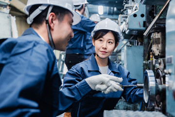 工場で作業を教えてもらう外国人労働者