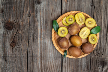 Closeup ripe golden kiwi fruit on wooden background. Healthy fruits concept. place for text, top...