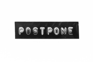 Black color banner that have embossed letter with word postpone on white paper background