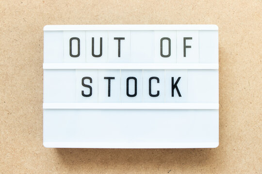 Lightbox with word out of stock on wood background