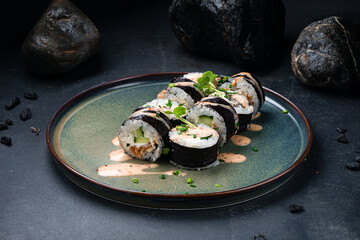 Japanese sushi rolls with eel, Philadelphia cheese, cucumber, rice, microgreens and chili nut sauce.