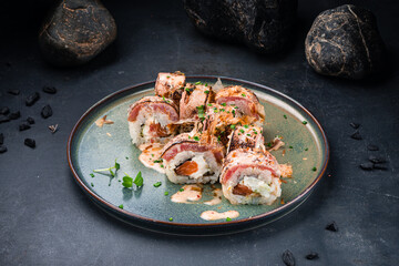 Japanese sushi rolls set with smoked tuna, Philadelphia cheese, salmon, avocado, tuna chips and sauce.