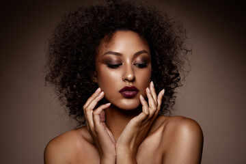 Fashion studio portrait of beautiful african american woman with perfect smooth glowing skin, make up