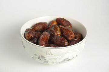 a bowl filled with a collection of dates with a plain white background