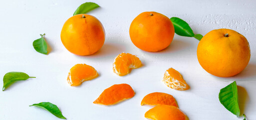 Fresh orange fruit and green orange leaf on a wooden white background, top view