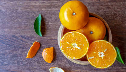 Fresh citrus fruit cut in half on a wooden bowl, top view of orange fruit