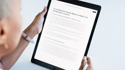 Student, lawyer scholarship and tablet online application while reading and doing research to study law with distance learning. Closeup woman scrolling on internet for information on college website