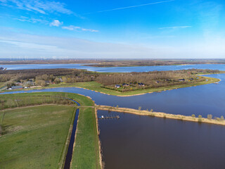 Fototapeta na wymiar aerial shot above oldambt early spring with sunny wheater with lake, water and blue sky