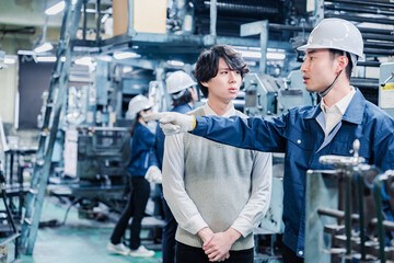 工場を見学する男子学生