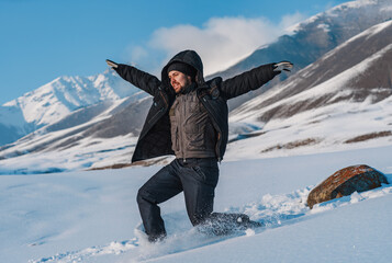 Fototapeta na wymiar Young man tourist sliding down from mountain at winter season